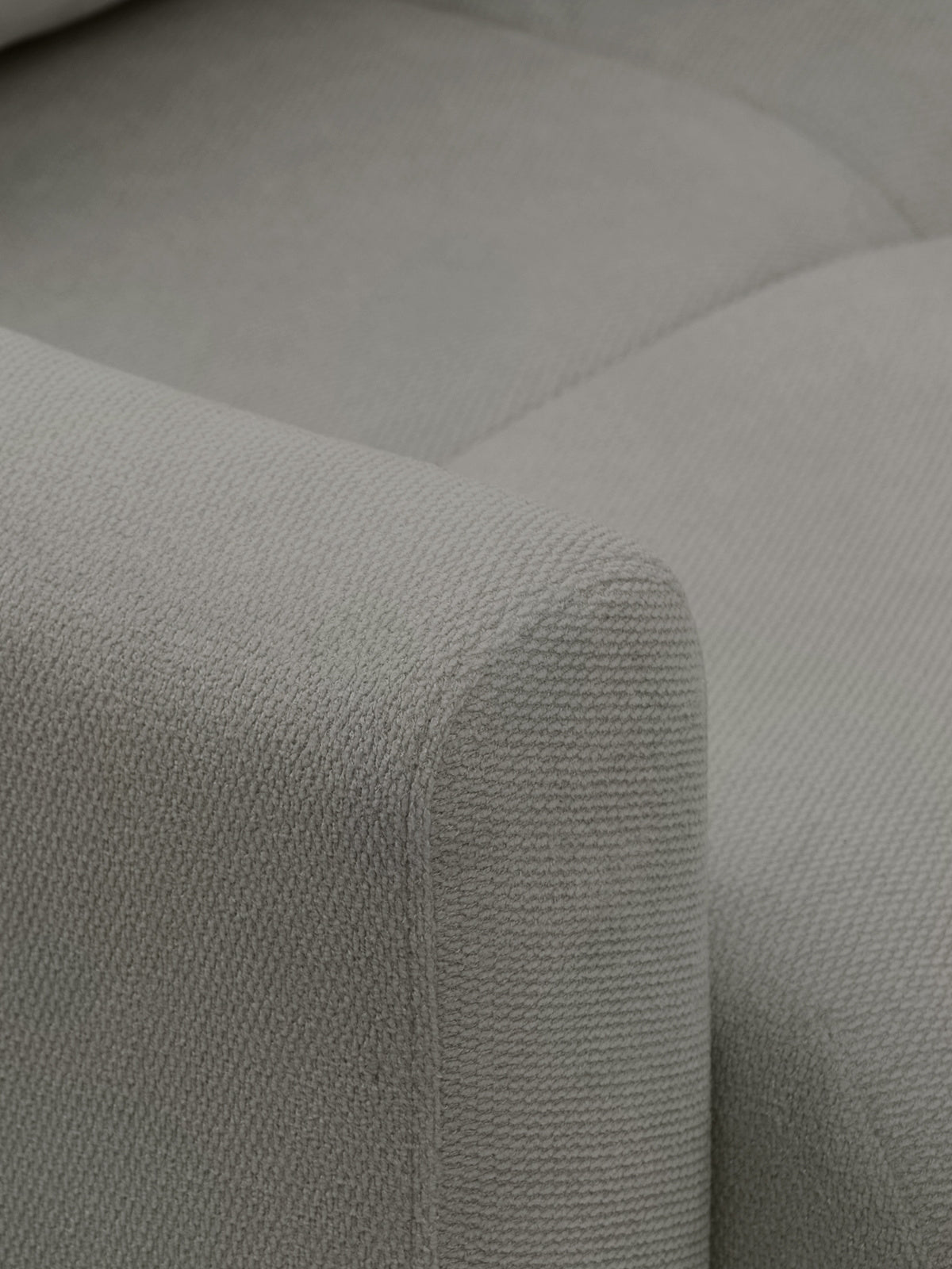 Detail opěrky a rohu pohovky Velaro v šedé tkanině Vela 86